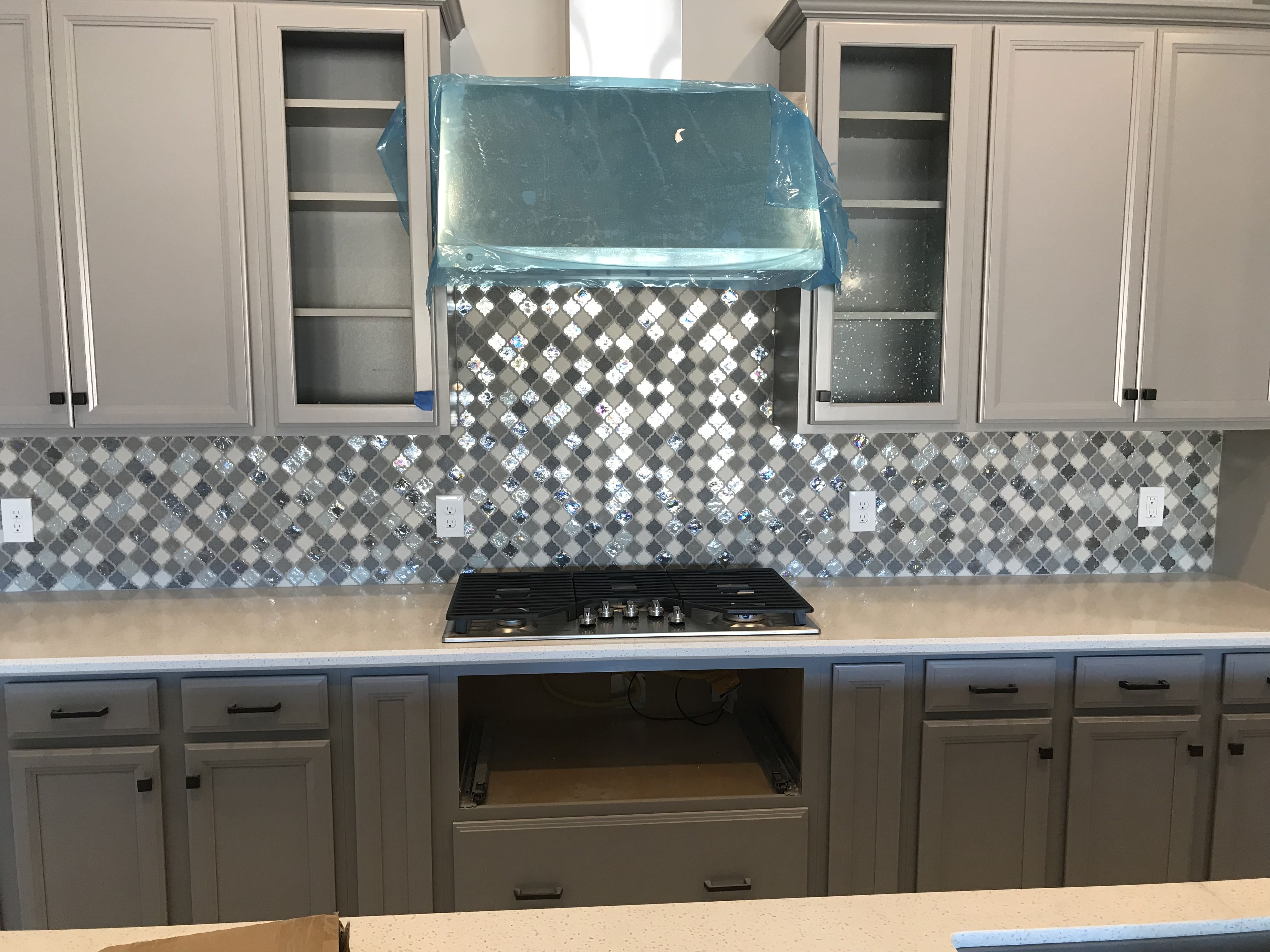 Navy blue shaker cabinets with white quartz countertops and glossy white picket tile backsplash