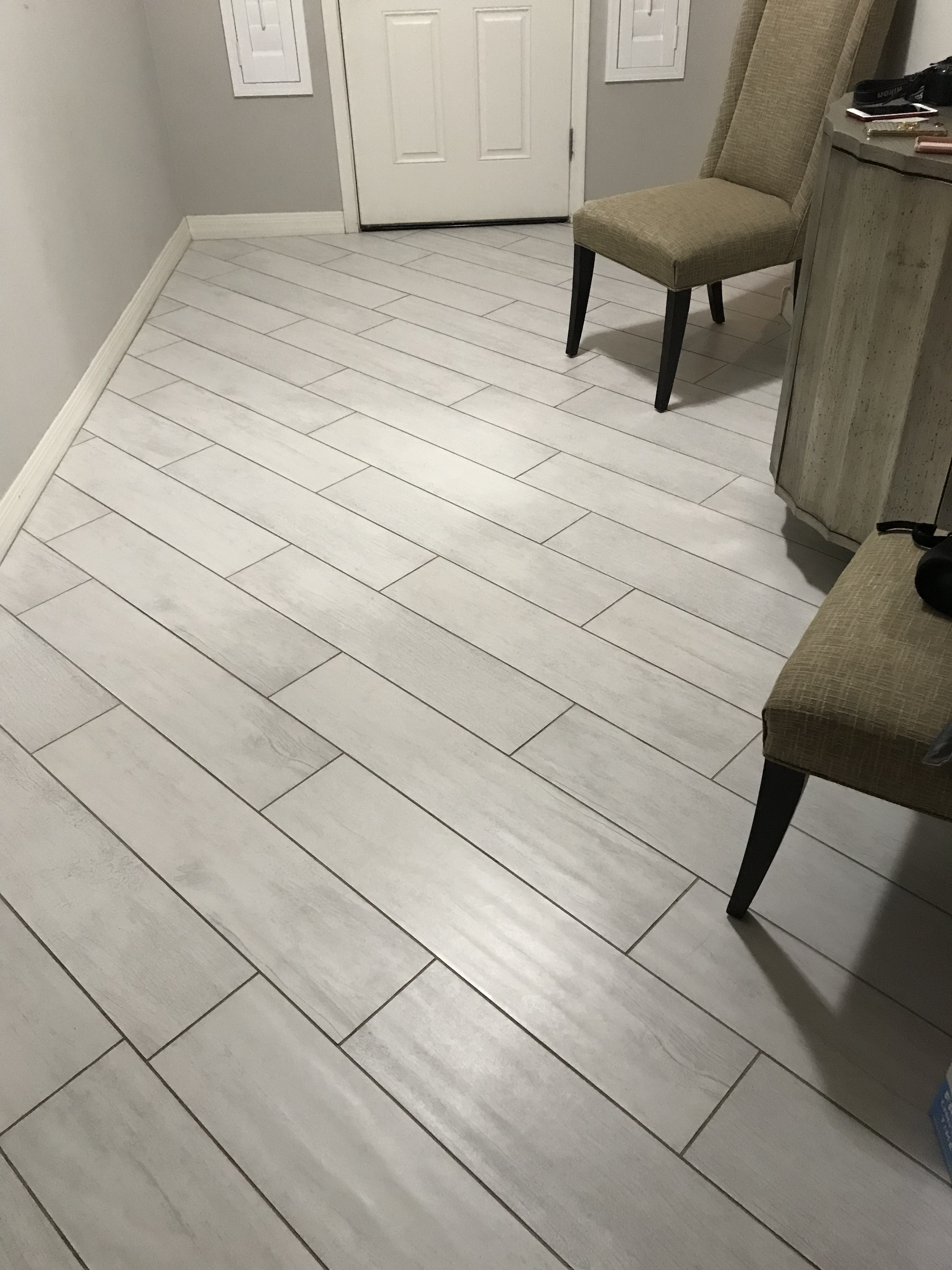 Large-format light gray tile floor in offset pattern with dark grout